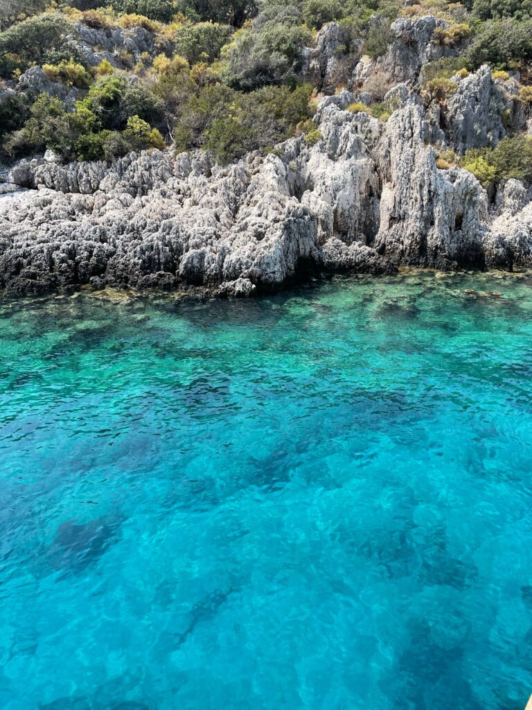Aerial view of a turquoise cove and rocky cliffs near Kas