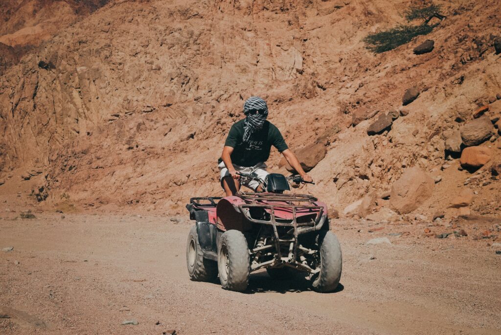 Man riding a quad bike on a dirt road