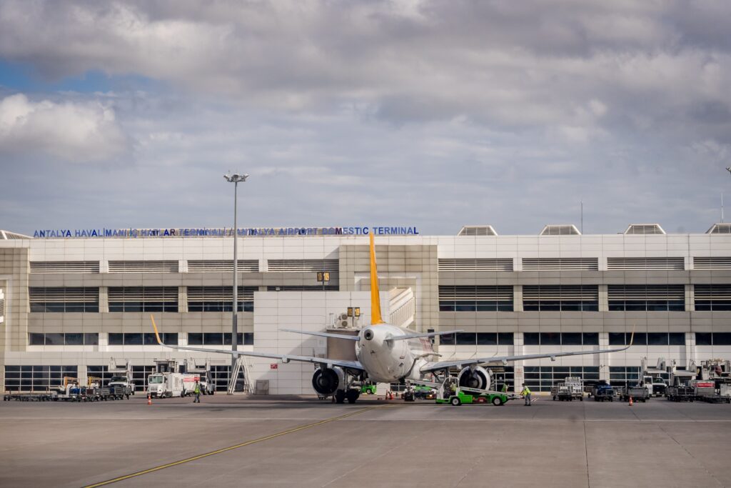 Airplane parked at Antalya Airport with terminal building in the background