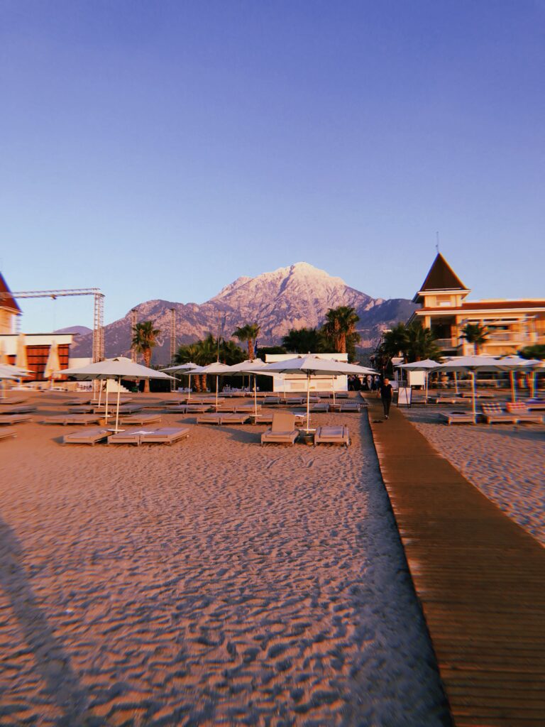 Golden sand beach with sun loungers and mountain view in Antalya