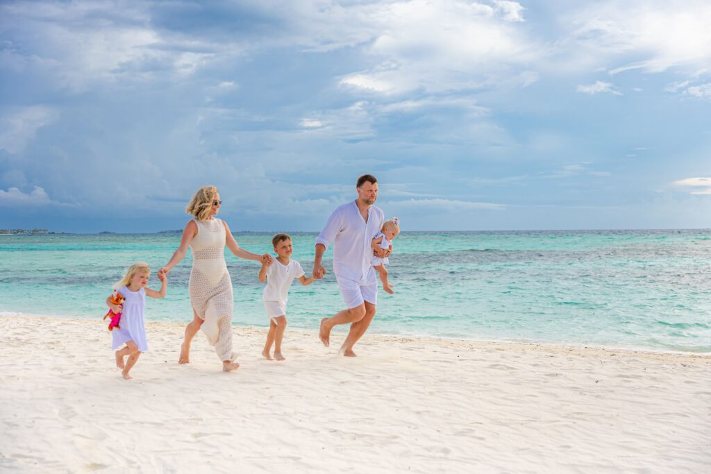 A joyful family strolls along a tropical beach