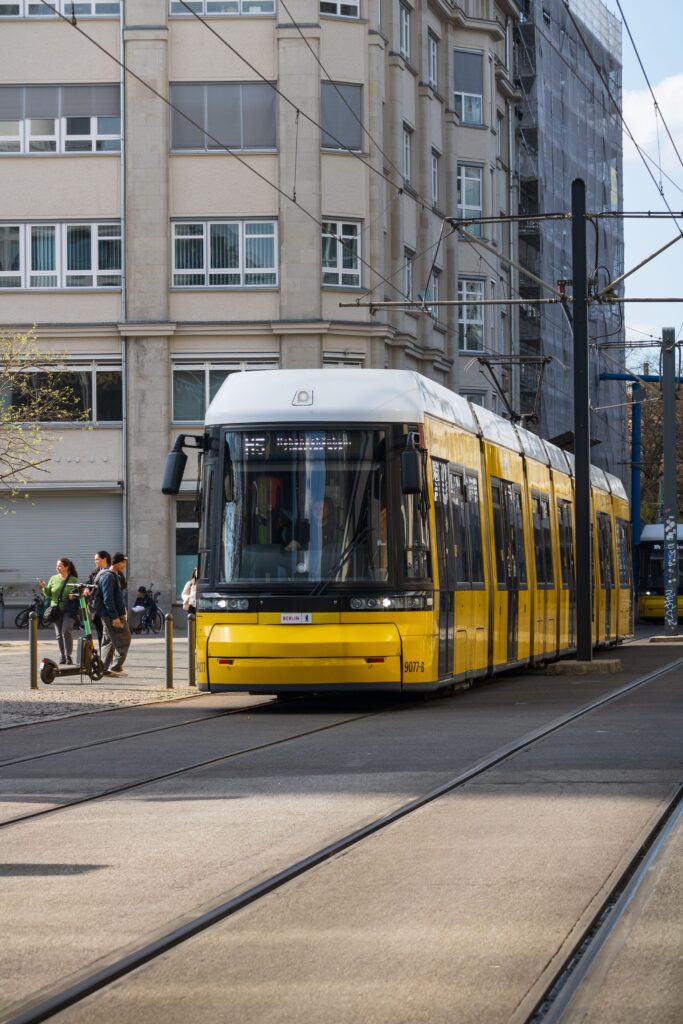 A yellow and white tram on a city street