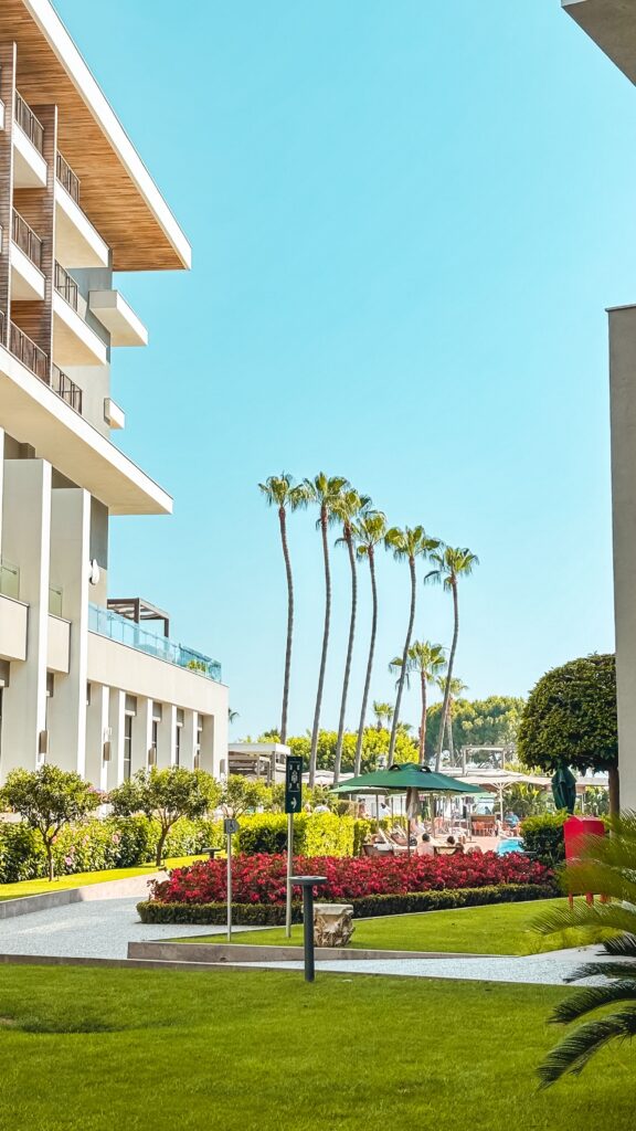 Luxury hotel exterior with palm trees and garden in Antalya