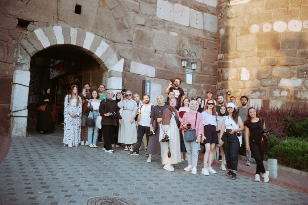 Group of tourists at a historic stone city gate in Antalya