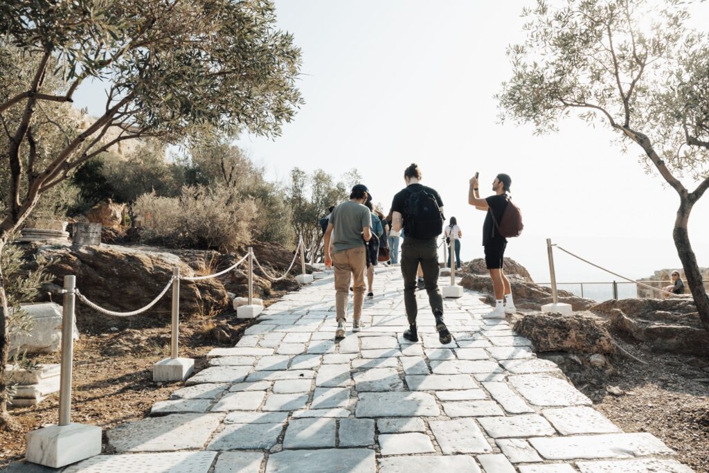 Tourists exploring an ancient stone walkway surrounded by trees