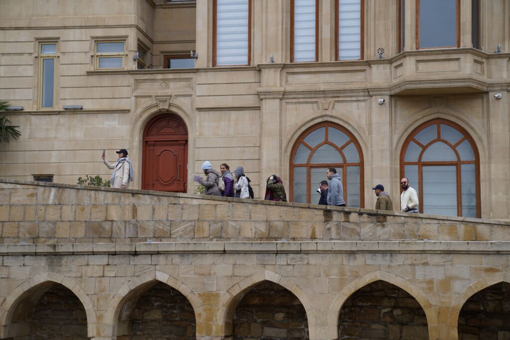 Tourists walking along a stone walkway of a historic building near Antalya