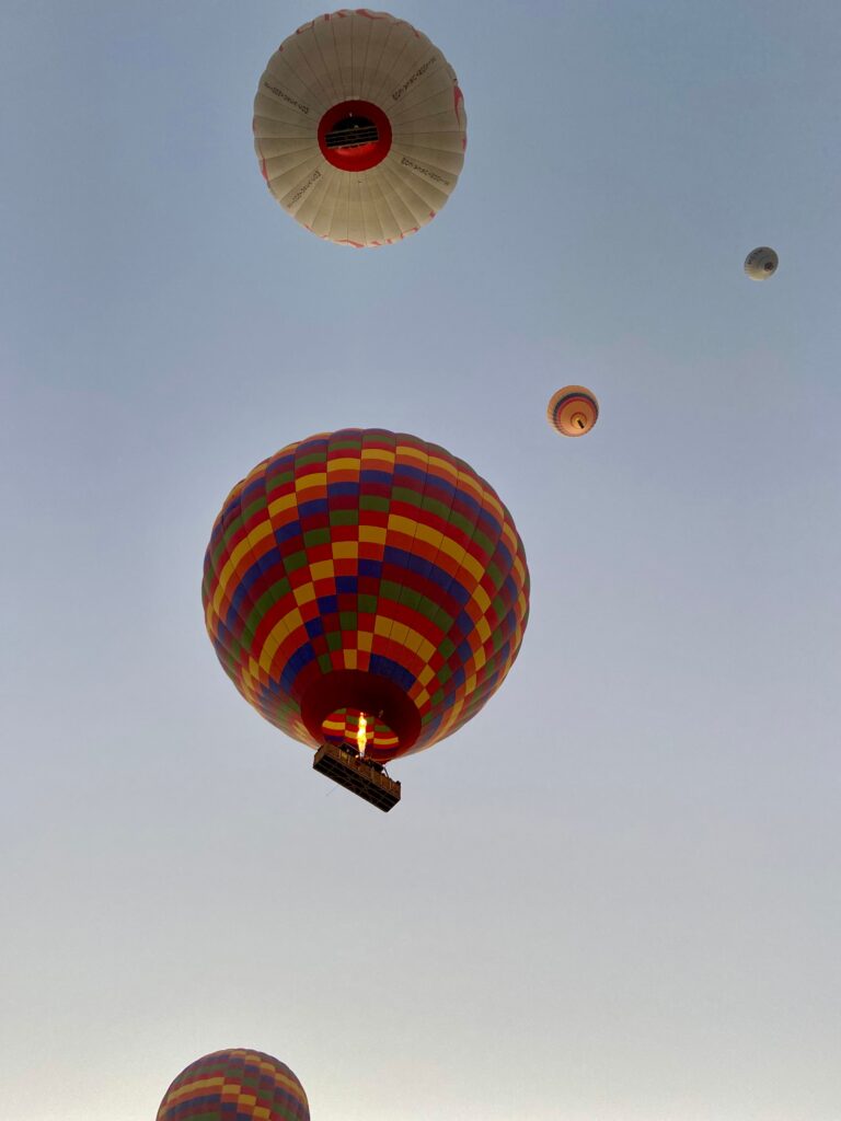 Colorful hot air balloons against a clear morning sky in Goreme, Turkey