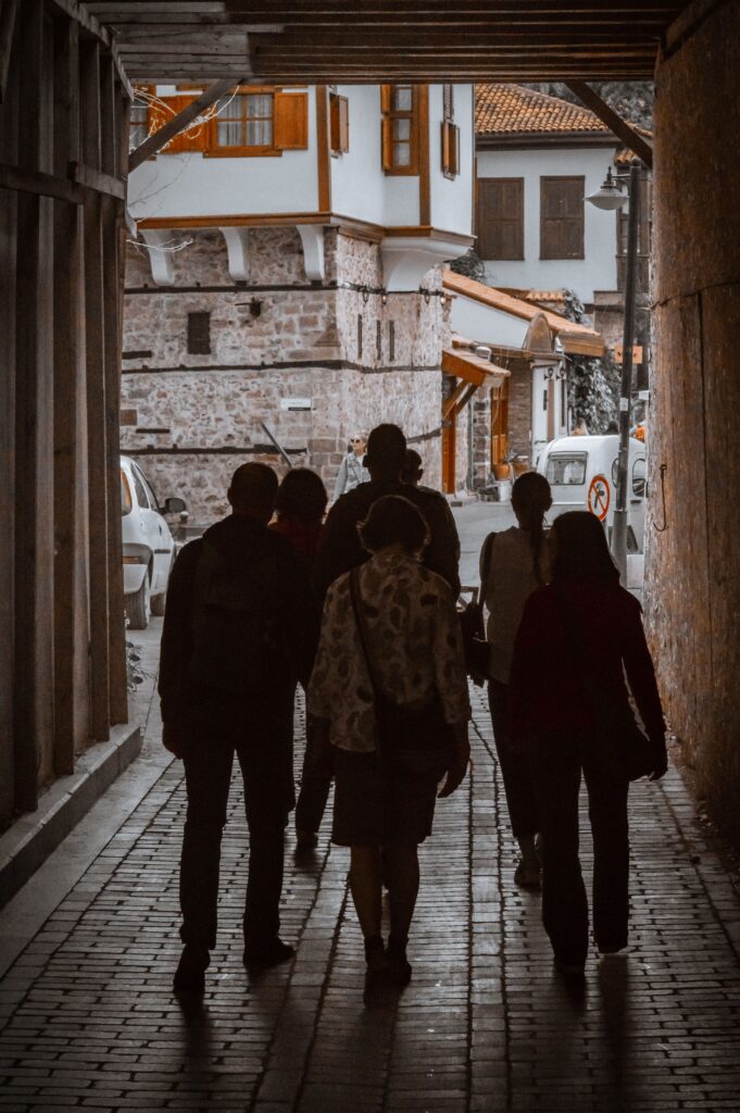 People walking under a historic archway in Antalya, Turkey