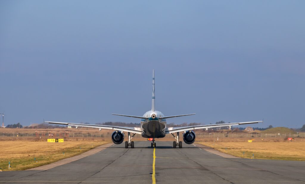 Commercial aircraft on airport runway at dawn
