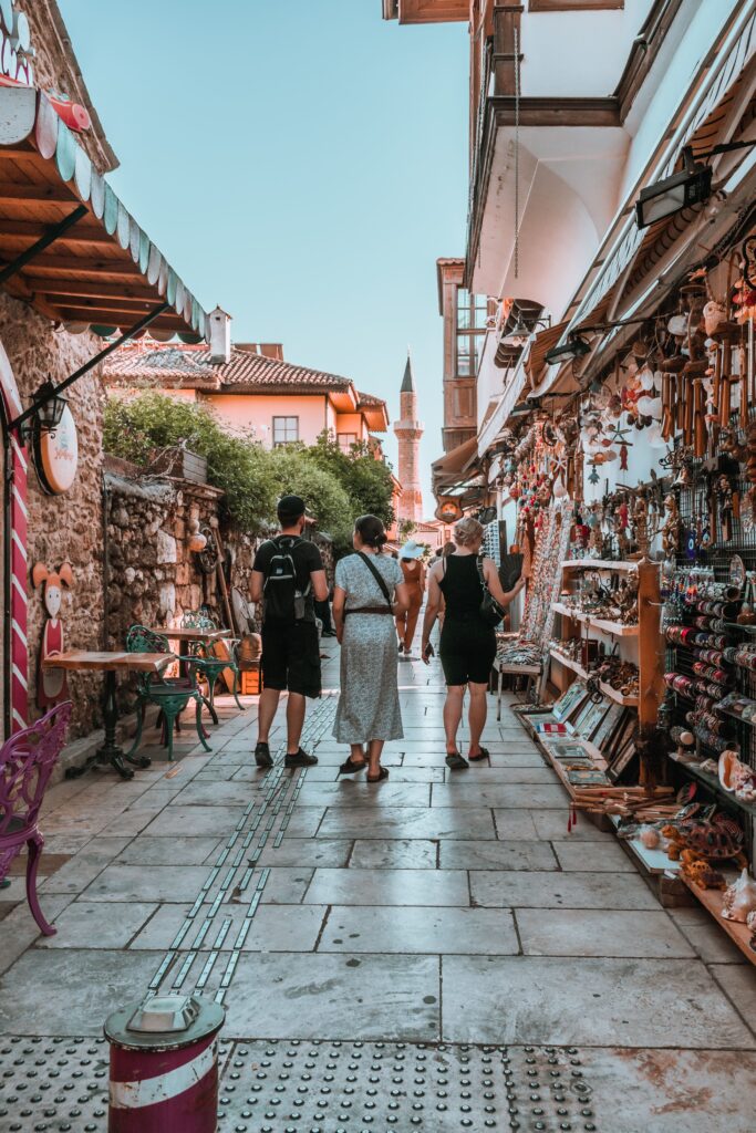 Visitors walk through a vibrant alleyway market filled with souvenirs
