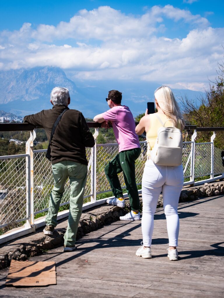 Adults enjoying a scenic mountain view over Antalya on a sunny day