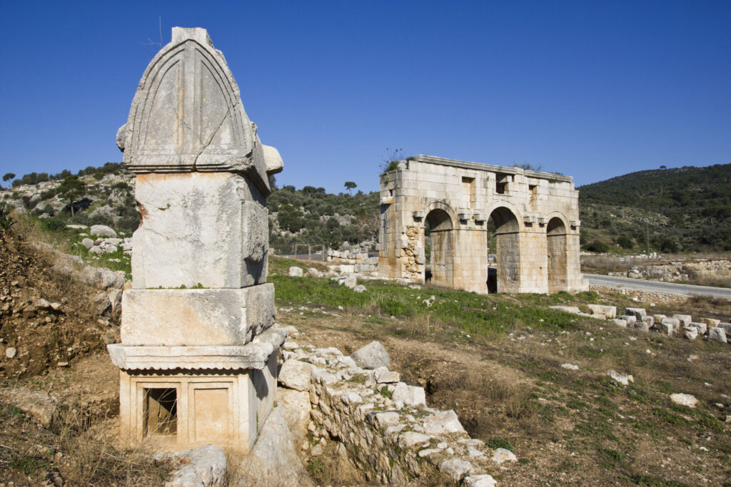 The triple-arched Gate of Mettius Modestus and a Lycian sarcophagus tomb at the ancient city of Patara, Turkey