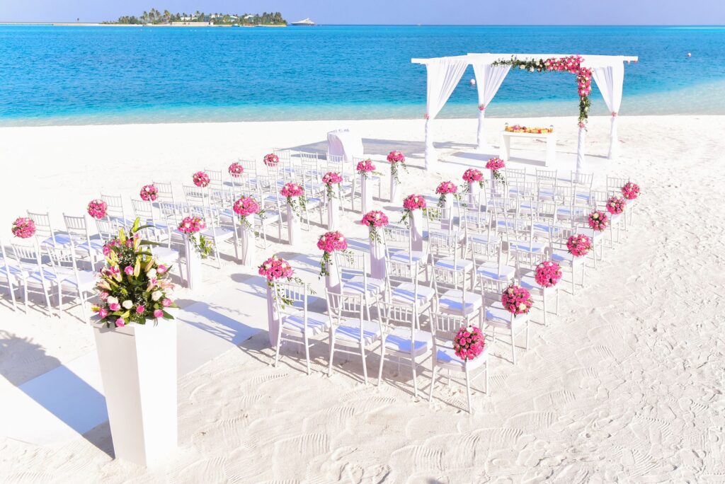 Beach wedding setup with floral arch and ocean view