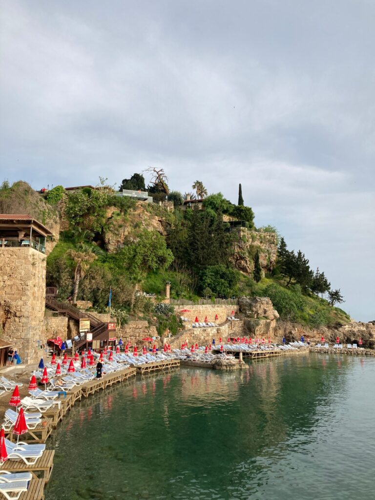 Rocky Antalya shoreline with sunbeds by the sea