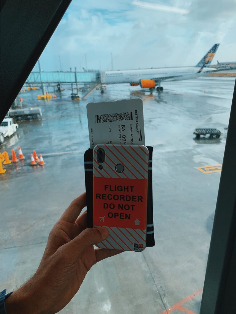 Traveller holding a smartphone and boarding pass at the airport before a flight to Antalya
