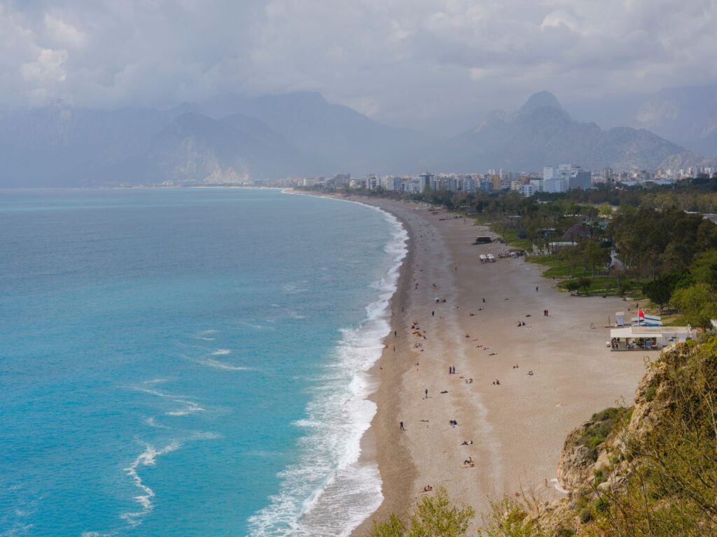 Aerial view of Konyaaltı Beach in Antalya with the city and mountains, reachable by tram